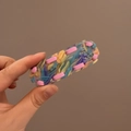 Détail d'une pince à cheveux en résine colorée avec bandes de tissu à l'intérieur - Rose