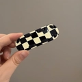 Détail du support téléphone à damier avec sangle noire tissée et texte HAE - Noir