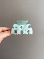 Detail of mint green marble acetate hair claw showing textured finish and geometric cutout - Blue