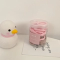 Gros plan d'élastiques à cheveux roses et marrons dans un pot avec une figurine de canard - Rose