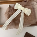Detailed close-up of cream lace bow hair clip with ribbons on vintage wooden display - Off-white Lace Long Ribbon Bow (D-5875-1)