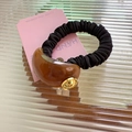 Minimalist elastic hair tie with black pleated fabric and brown amber acrylic detail - Brown