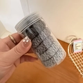 Detalle de gomas para el pelo en degradado gris en un bote de plástico portátil - Gris
