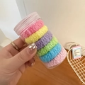 Close-up of colorful macaron-colored elastic hair ties in a transparent storage jar - Colorful