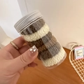Close-up of colorful plush hair scrunchies in a clear jar with a silver lid for storage - Grey Gradient Style (D-4862-6)