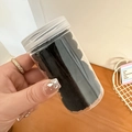 Primer plano de gomas de pelo en un tarro cilíndrico de plástico con tapa blanca - Negro