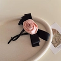 Haarklammer mit rosa Satinrose und schwarzer Schleife auf einem Tablett, elegantes Accessoire - Rosa