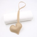 Macro detail of heart-shaped beige leather charm with white contrast stitching and cord - Heart Strap / Khaki
