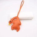 Detail of creative orange leather roast duck bag charm with textured litchi grain finish - Roasted Duck Style / Orange