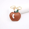 Detailed close-up of brown PU leather apple keychain with golden lobster clasp and metal ring - Brown