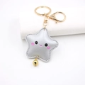 Dettaglio portachiavi a stella in pelle argento con faccina e campanellino dorato - Stile Chiusura A Aragosta / Argento