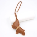 Close-up of brown leather French Bulldog bag charm with fine stitching and golden hardware - Brown