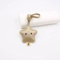 Close-up of champagne gold leather star keychain with cute smiley face and small bell - Strap Style / Gold