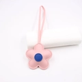 Dettaglio di un ciondolo a fiore in pelle rosa con centro blu e laccio coordinato - Rosa