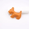 Detailed view of dog-shaped orange leather pendant accessory with neat edge stitching - Orange