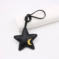 Dettaglio ciondolo borsa a stella in pelle nera con toppa luna gialla e cuciture - Stella della Buonanotte / Nero