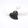 Dettaglio macro del portachiavi in pelle a forma di cuore con stampa leopardata e anello - Verde Scuro