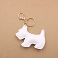 Macro shot of white lychee-patterned leather Scottie dog keychain with gold-tone hardware - White