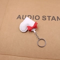 Detailed close-up of a white heart leather keychain featuring a bright red bow decoration - White