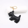 Detailed view of a black leather Scottie dog keychain with gold metal hardware and stitching - Black