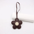 Close-up of dark brown leather flower bag charm with fine stitching and creamy white center - Dark Brown