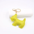 Detail view of a bright yellow leather dog keychain with gold hardware and white stitching - Yellow-Green