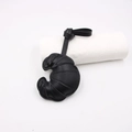 Detail of black croissant leather bag charm with visible topstitching and adjustable strap - Black