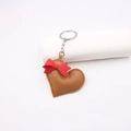 Brown leather heart keychain with a red bow decoration and silver metal key ring - Brown