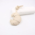 Detail of cream croissant leather pendant featuring pebble grain texture and neat stitching - Beige
