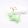 Detail view of light green leather puppy keychain with gold lobster clasp on white pedestal - Light Green