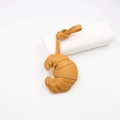 Detailed macro view of yellow leather croissant bag charm with matching hanging lanyard strap - Khaki/Earth Yellow
