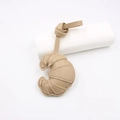 Macro view of khaki leather croissant pendant with detailed stitching and strap - Khaki