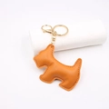 Close-up of orange leather Scottie dog keychain with gold-tone hardware and fine stitching - Orange