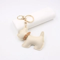 Dettaglio portachiavi a forma di cane schnauzer in pelle beige con cuciture e anello dorato - Bianco Sporco