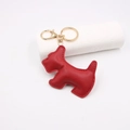 Vista dettagliata del portachiavi a forma di cane in pelle rossa con gancio dorato - Rosso