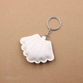 Detalle de llavero de concha en cuero PU blanco con costuras acolchadas y aro metálico - Blanco