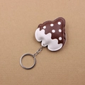 Macro shot of brown mushroom leather keychain with white dots and silver metal ring - Brown