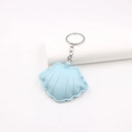 Detailed view of light blue leather shell keychain with high-quality stitching and silver ring - Blue