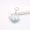 Macro detail of laser iridescent shell keychain with silver metal ring and stitch texture - Holographic Silver White