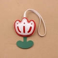 Détail macro du charm de sac en cuir tulipe avec pétales rouges et couture de feuille - Rouge