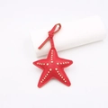 Dettaglio ciondolo borsa a stella marina in pelle rossa con borchie punk dorate e cuciture - Rivetto Stella Marina (zg 001) / Rosso