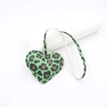 Detail of leopard print heart pendant with visible stitching on litchi leather texture - Green