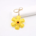 Nahaufnahme von gelbem Sonnenblumen-Leder-Schlüsselanhänger mit goldener Kette und Haken - Sonnenblume Stil / Gelb