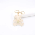 Detailed view of beige leather bear keychain with golden clasp and fine stitching - Bear / Off-white