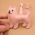 Close-up of pink litchi grain leather dog charm with matching stitching for bags - Pink