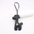 Detalle de colgante de jirafa en cuero negro con costuras finas y cadena dorada - Negro