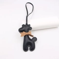 Detailansicht eines Giraffen-Taschenanhängers aus schwarzem Leder mit brauner Schleife - Lanyard Schleife Giraffe / Schwarz
