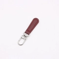 Macro detail of burgundy leather zipper pull with red stitching and silver lobster clasp - Wine Red