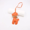 Détail du pendentif girafe en cuir synthétique orange avec un nœud marron - Cordon Nœud Girafe / Orange