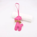 Détail du pendentif caniche en cuir rose avec texture litchi et nœud papillon brun - Cordon Nœud Girafe / Rouge Rose